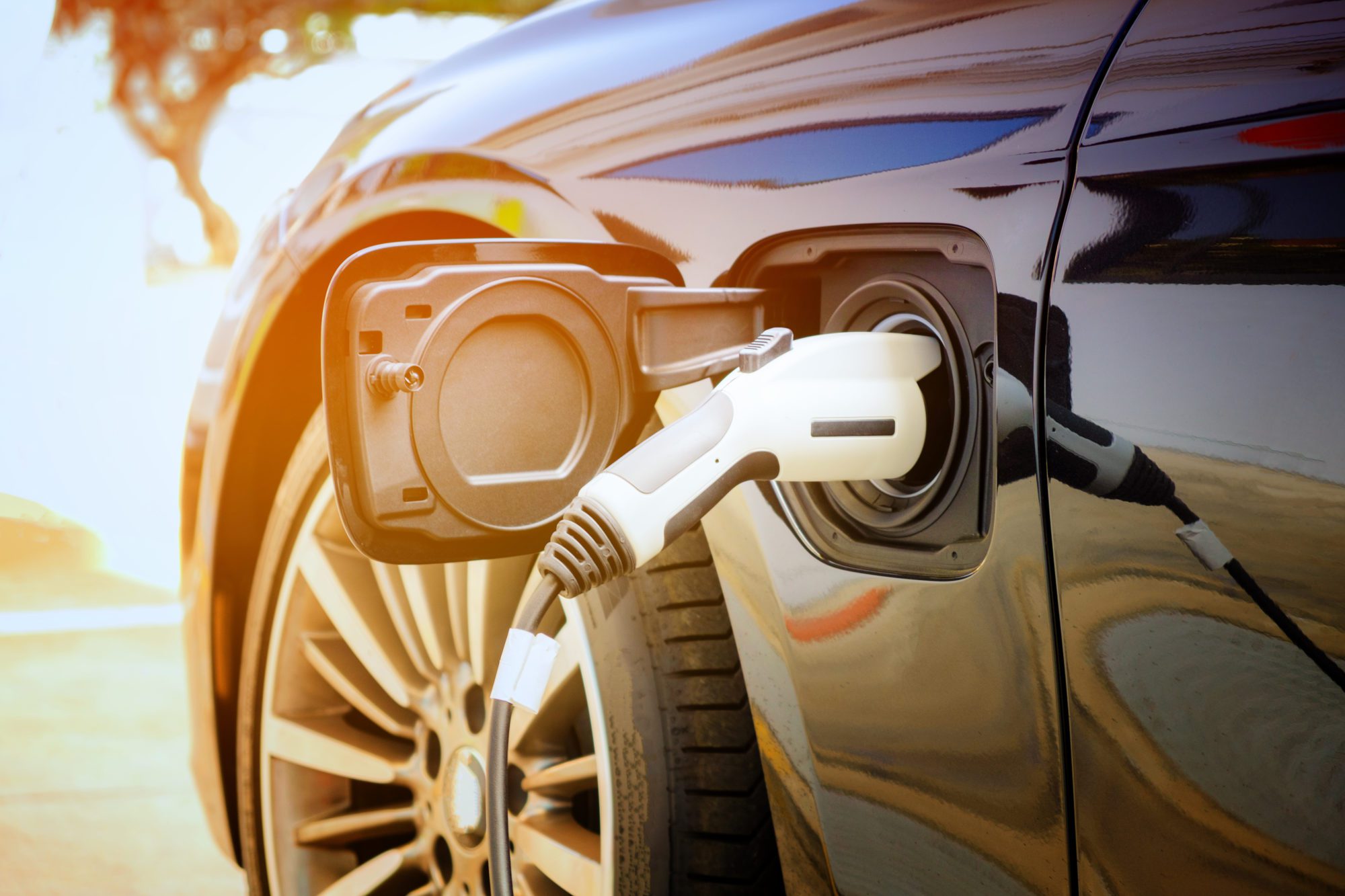 An electric vehicle being charged at a charging station