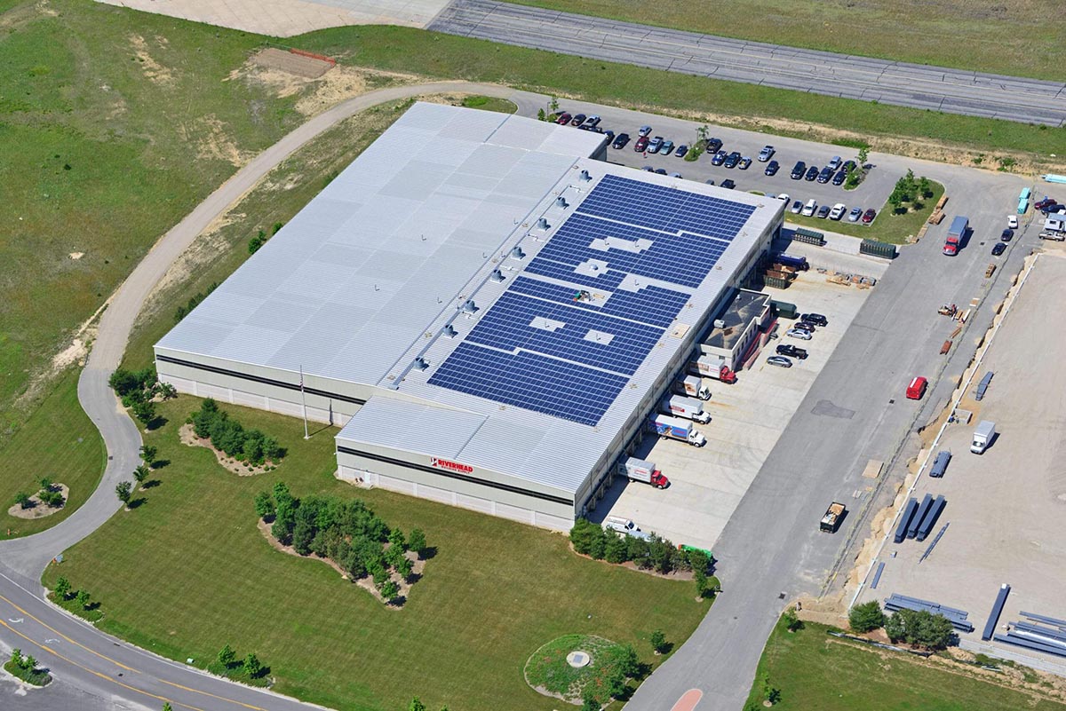 Aerial view of a rooftop commercial solar installation on a warehouse