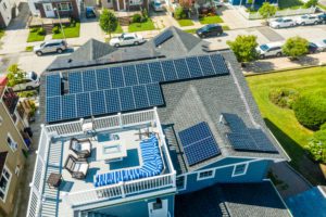 A house on Long Island has a rooftop deck. Their roof also has solar panels so the house may use solar energy. 