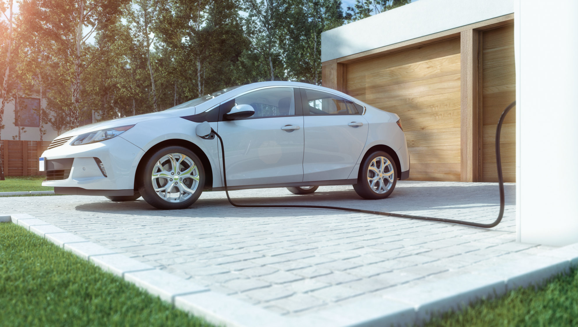 A white electric vehicle is being charged at a home charging station.