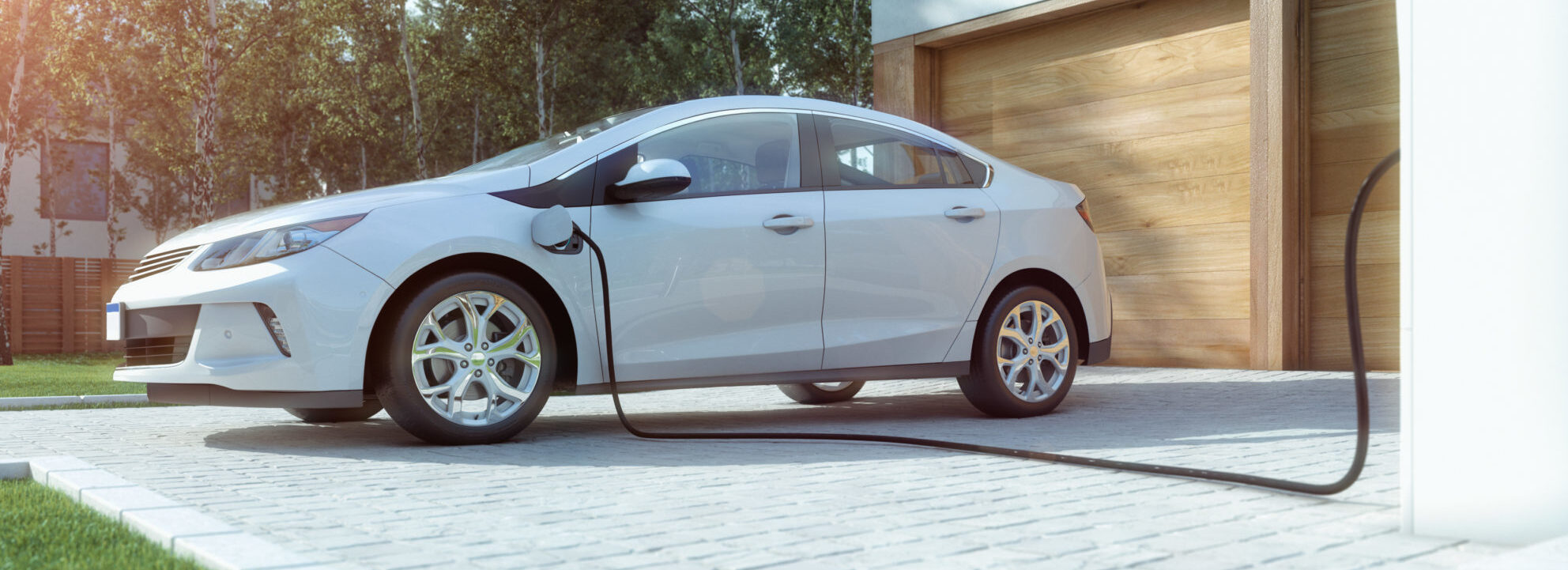 A white electric vehicle is being charged at a home charging station.